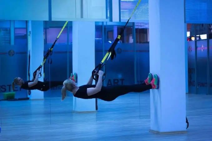 Két nő TRX-es teremedzés közben 