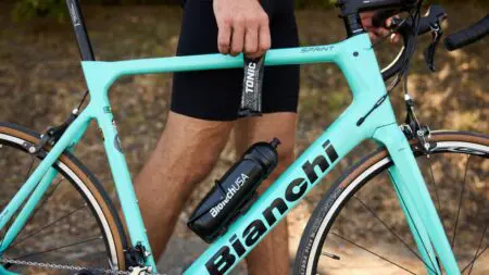 Férfi a kerékpárversenyen izotóniás itallal frissít