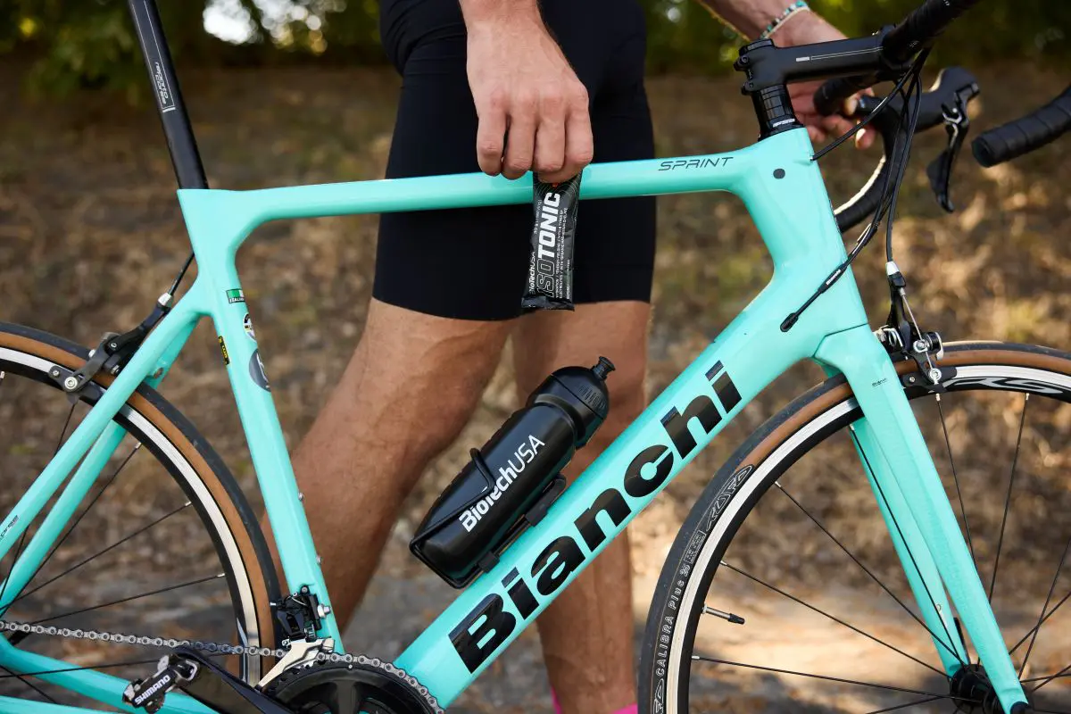 Férfi a kerékpárversenyen izotóniás itallal frissít