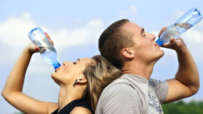Nő és férfi palackból vizet iszik 